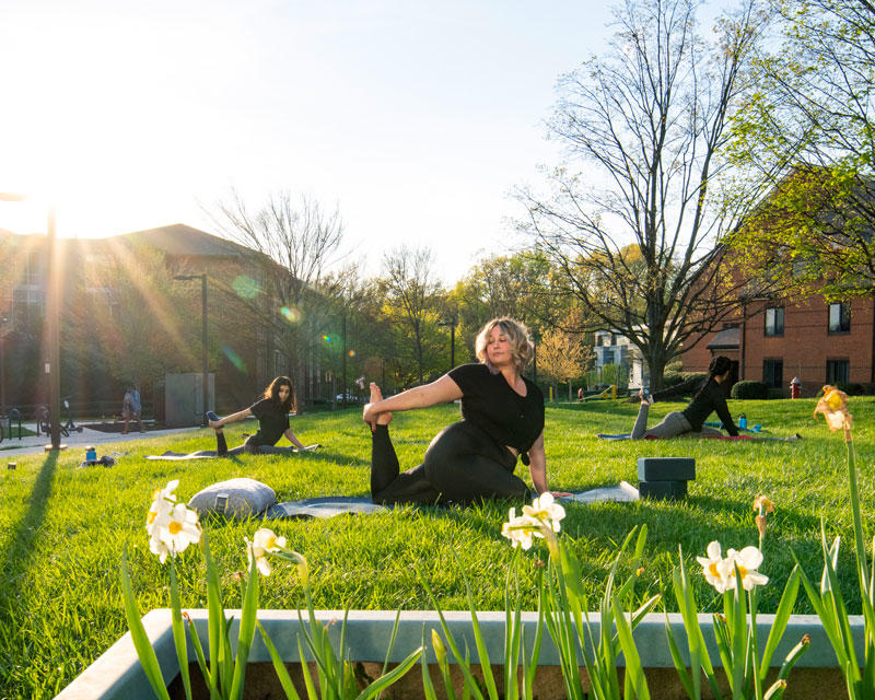 Participants in a Mason Rec yoga practice outdoors on a spring day